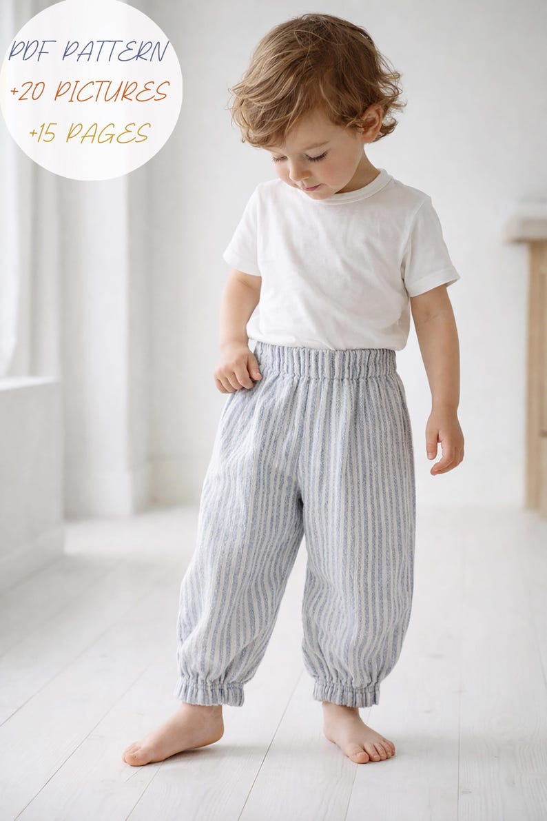 May include: A PDF pattern document featuring 15 pages and 20 pictures for sewing pants. The pants are light gray with vertical white stripes, featuring an elastic waistband and elasticized cuffs at the ankles, paired with a plain white t-shirt.
