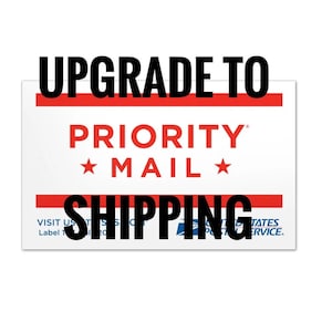 May include: Upgrade to Priority Mail Shipping. A white label with red and blue accents. The text "Upgrade to Priority Mail Shipping" is in black. The text "Priority Mail" is in red with a star on either side. The text "Visit us at USPS.com" is in blue.