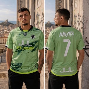 May include: A light green short-sleeved jersey featuring a black crew neck and hem. The front displays the text JUL, TOTO & NINETTA, and a logo. The back features the text NINETTA, the number 7, and the text JUL in white lettering.