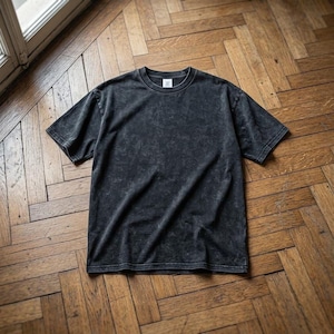 Peut inclure: Un t-shirt gris foncé, de style délavé à l'acide, avec un col rond et des manches courtes. Le t-shirt a un aspect légèrement délavé, lui donnant un aspect vintage. Le tissu semble doux et confortable, adapté aux tenues décontractées.