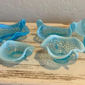 Puede incluir: Colección de fuentes de vidrio vintage en tonos azules y blancos. Incluye un jarrón con volantes, fuentes con forma de cisne, una crema, una jarra y una fuente para servir. El vidrio tiene un diseño texturizado.
