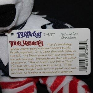 May include: A white, red and blue plush toy with a tag that reads "Birthday Tour Memory" and includes details about a concert on 4th July 1987 at Schaefer Stadium in Massachusetts. The tag also includes a barcode.