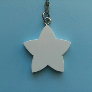 May include: A white, five-pointed star-shaped pendant hanging from a silver chain. The star is solid and smooth, set against a light blue background. The pendant is a simple, minimalist design.