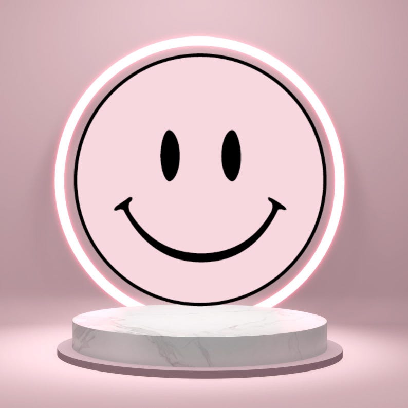 May include: A pink smiley face with black eyes and a curved mouth, set against a pink background. The smiley face is surrounded by a white neon light. The design is displayed on a white marble-patterned pedestal.