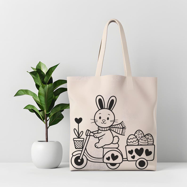 K&ouml;nnte beinhalten: Beige Tragetasche mit einer schwarz-wei&szlig;en Illustration eines Hasen auf einem Roller, der einen Anh&auml;nger mit Ostereiern zieht. Der Hase tr&auml;gt einen Schal und der Anh&auml;nger hat Herzdetails. Links ist eine Topfpflanze.