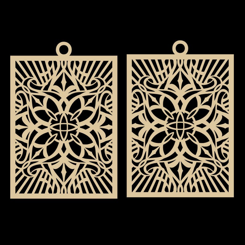 May include: Two laser-cut, beige-colored earrings with an intricate floral and geometric design. Each earring is rectangular with a small circular loop at the top for hanging. The design features a central floral motif surrounded by swirling patterns and linear elements.