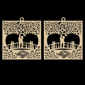 May include: Two laser-cut wooden panels featuring a romantic scene. Each panel depicts a couple embracing on a bridge under a tree, with floral and water details. The panels have a natural wood color and a small hole for hanging.