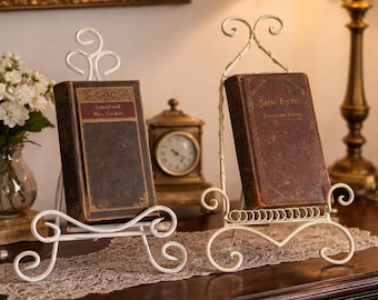 Juego de 2 soportes metálicos vintage para libros, expositores con elaborados detalles ornamentales y acabado envejecido color crema.