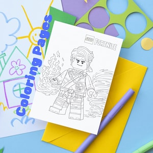 May include: A coloring page featuring a Lego Fortnite character with flames and a tornado. The page is on a blue surface with colorful paper cutouts, a yellow envelope, and markers. Text on the page reads "Lego Fortnite".