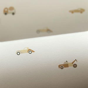 May include: A light beige background with scattered illustrations of toy cars in various shades of brown and beige. The cars have black wheels and are in different styles, including a tow truck.