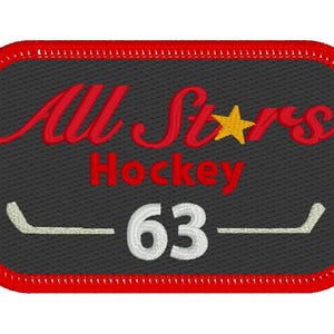 May include: Embroidered patch with a red border and a dark gray background. The patch features the words "All Stars Hockey" in red script, a gold star, the number "63" in white, and hockey stick graphics.