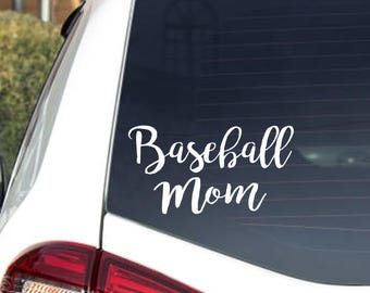 May include: White vinyl decal with the words "Baseball Mom" in a cursive font, affixed to the rear window of a white vehicle. The decal is positioned above the taillight.