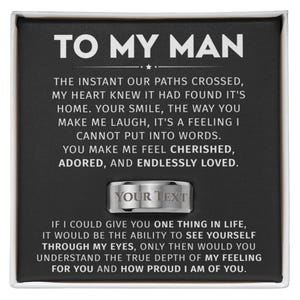 May include: A silver ring with the text "YOUR TEXT" engraved on it, presented in a black box with the words "TO MY MAN" at the top. The box contains a heartfelt message about love and appreciation.
