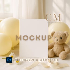 May include: A blank white card mockup with the word "MOCKUP" in a light brown font. The scene includes a teddy bear, yellow balloons, daisies, and a cream-colored ribbon. The image also includes the text "PSD SMART OBJECT | JPG".
