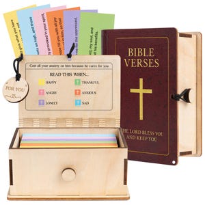 Puede incluir: Una caja de madera con un cajón que contiene tarjetas coloridas y un libro con forma de Biblia. La caja tiene una etiqueta que dice "FOR YOU". El libro tiene impreso "BIBLE VERSES" en la portada. Las tarjetas tienen versículos bíblicos.