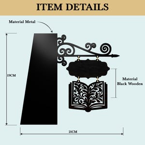 May include: Black metal and wooden sign, shaped like an open book with decorative cutouts, hanging from a metal bracket. The sign is 21 cm wide and 19 cm tall. The sign reads "ITEM DETAILS".