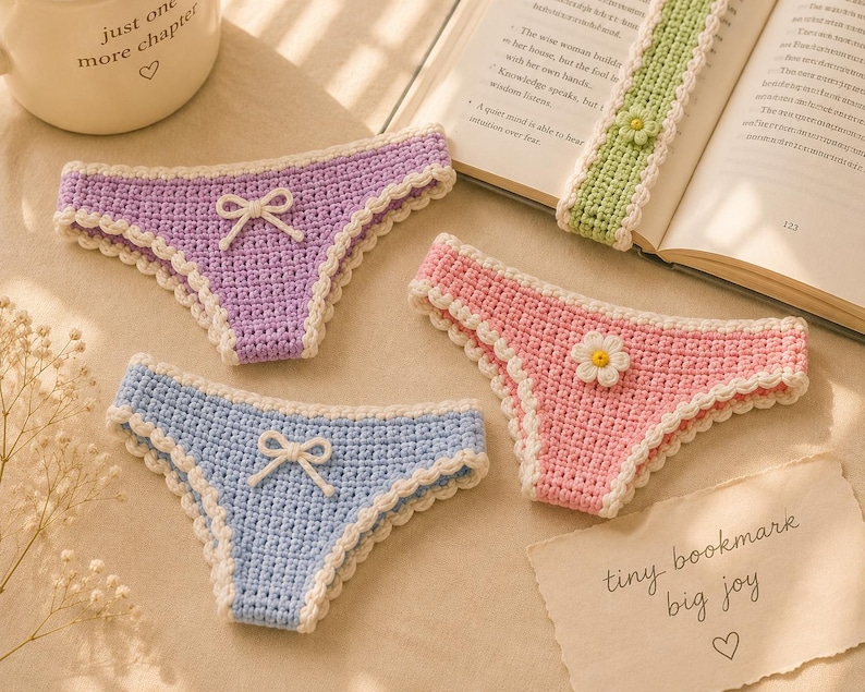 May include: Crocheted bookmarks shaped like underwear in pastel colors: purple, pink, and blue. Each has a white scalloped trim and a bow or flower detail. A green bookmark with a flower is also present. The text "tiny bookmark big joy" is visible.