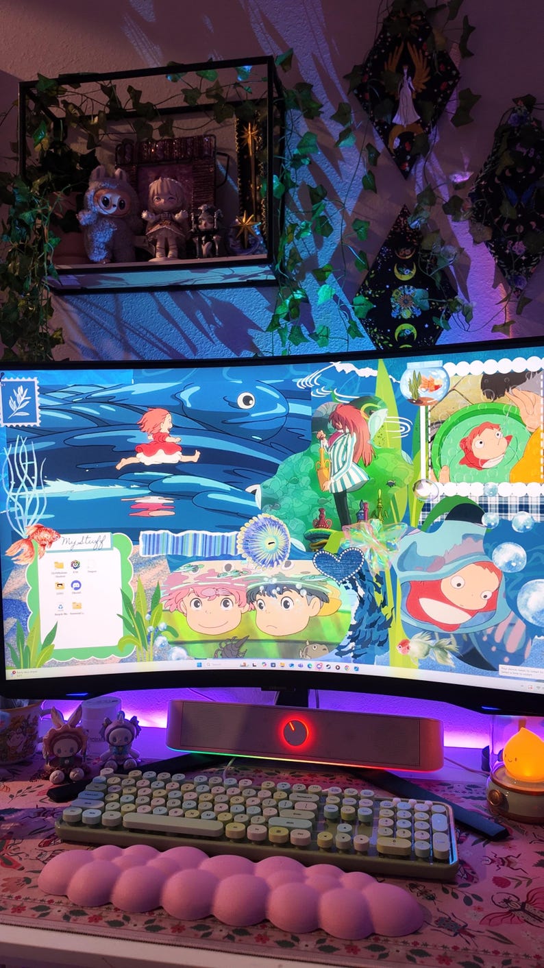 May include: A computer setup featuring a curved monitor displaying a vibrant anime-style wallpaper with characters and aquatic themes. A keyboard, wrist rest, and speakers are visible, along with decorative figurines and a small lamp, creating a colorful and themed workspace.