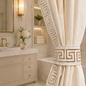 May include: A cream-colored curtain featuring a prominent gold Greek key pattern along the vertical edge and a matching tieback. The fabric has a smooth, matte texture, and the geometric border design is repeated on the wide, structured tieback.