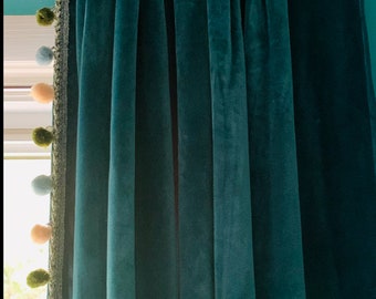 Può includere: Tende in velluto turchese con un bordo decorativo con pompon colorati. Il bordo è sul lato sinistro delle tende.