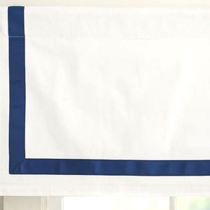 Puede incluir: Valance blanca con un ribete azul marino alrededor de los bordes.