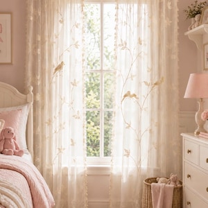 Pu&ograve; includere: Una coppia di tende trasparenti color bianco sporco con un motivo ricamato di delicate viti, foglie e piccoli uccelli. Le tende sono appese a un bastone dorato e presentano piccole nappe decorative lungo i bordi verticali del tessuto.