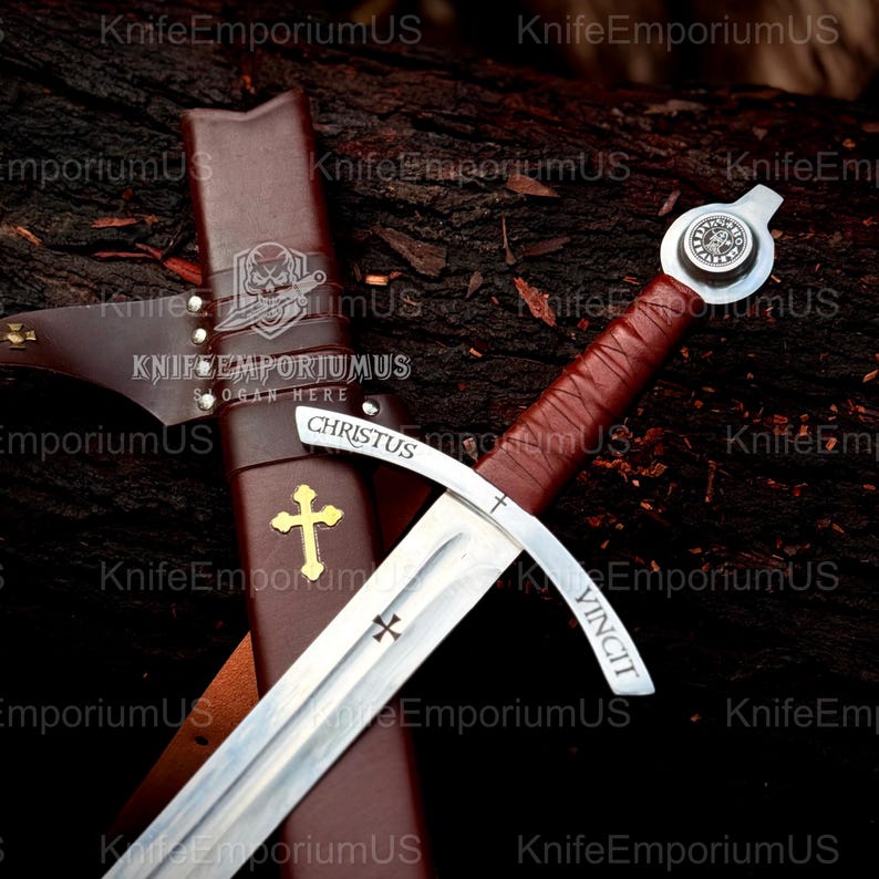 May include: A medieval sword with a silver blade and a brown leather-wrapped handle. The sword features a cross-shaped guard and a pommel with a circular emblem. The scabbard is brown leather with a gold cross and the word "CHRISTUS".