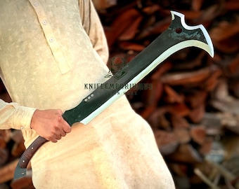 May include: A large, curved blade with a dark finish and a polished edge. The handle is made of wood and has a curved design. The blade has a unique shape with a pointed tip and a cutout near the top. The text "KNIFEEMPORIUMUS" is visible.