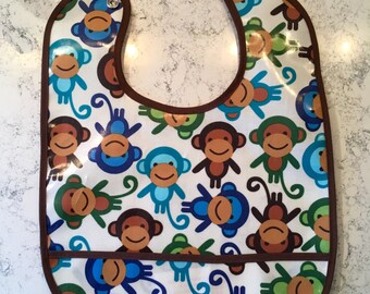 Laminated bib with adorable monkeys and pocket