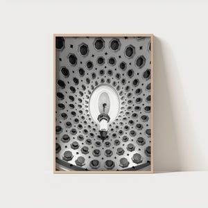 Puede incluir: Fotografía en blanco y negro de un techo con un patrón geométrico repetitivo de octágonos y círculos. Una lámpara cuelga del centro. La imagen está enmarcada en un marco de madera clara.