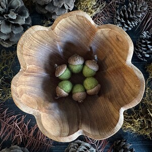 Pu&ograve; includere: Una ciotola di legno con un bordo a festoni, piena di sei ghiande di feltro verde.