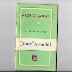 May include: Green maintenance book for the Aronde P60 car. The cover features the car's logo, a stylized bird in flight, and the text "Aronde P60 Maintenance Book" and "Your Aronde!" The bottom of the cover has a small logo that says "Aronde Simca".