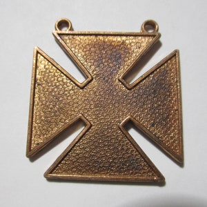 Peut inclure: Un pendentif en forme de croix en métal doré avec une surface texturée. La croix a une boucle en haut pour l'accrocher.