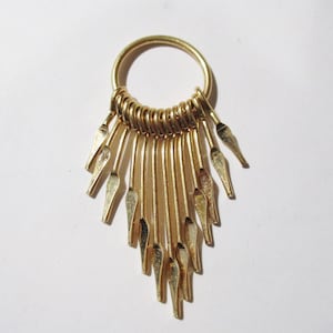 May include: Gold-toned metal earring with a circular hoop and a fringe of dangling, pointed metal pieces.