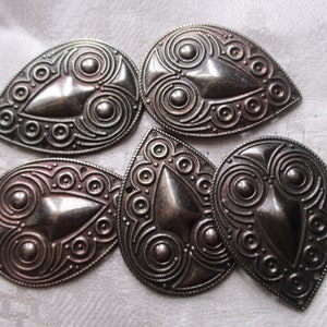 May include: Five silver teardrop-shaped metal charms with intricate Celtic-inspired designs. Each charm features a central teardrop shape surrounded by concentric circles and dots.