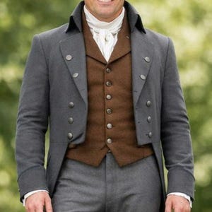 Könnte beinhalten: Ein grauer Gehrock mit silbernen Knöpfen, kombiniert mit einer braunen Weste und grauer Hose. Das Outfit umfasst eine weiße Krawatte und ein hochgeschlossenes Hemd. Ein klassisches Beispiel für historische formelle Kleidung.