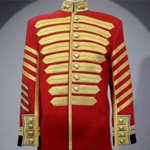 May include: A red military jacket with gold trim and buttons. The jacket features multiple gold stripes across the chest and sleeves, with gold detailing on the collar and cuffs. The jacket has a high collar and a row of gold buttons down the front.