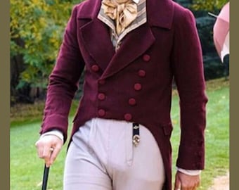 Puede incluir: Un frac burdeos de doble botonadura con botones a juego, combinado con pantalones de color claro y un chaleco estampado. El abrigo tiene un diseño clásico y formal, adecuado para recreaciones históricas o eventos temáticos.