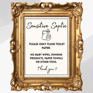 May include: A decorative gold-colored framed sign with the text "Sensitive Septic" and instructions to only flush toilet paper. The sign also includes a drawing of a toilet paper roll.