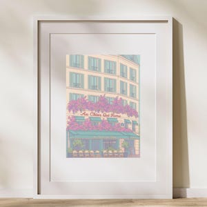 Puede incluir: Impresión artística enmarcada de un café parisino. El edificio beige tiene contraventanas azules y un toldo verde. El café está adornado con flores rosas, y se ve el texto "Au Chien Qui Fume".