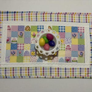 Pode incluir: Uma caneca de cer&acirc;mica branca com uma al&ccedil;a preta e o texto "But First, Coffee" em preto, com uma fonte manuscrita. A caneca est&aacute; sobre uma superf&iacute;cie branca.