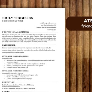May include: A resume template with the name "Emily Thompson" and the title "Professional Title" is displayed on a wooden background. The resume includes sections for a professional summary, experience, education, and skills. A brown rectangle with the text "ATS friendly" is in the upper right corner.