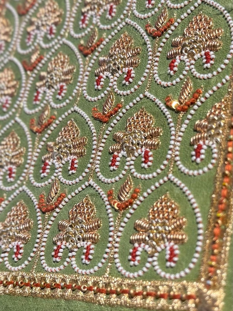Close-up of gold zari, pearl beads and red thread hand embroidery on green silk, a premium handmade gift for girlfriend, boyfriend, husband or wife.
