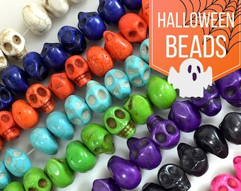 May include: A strand of colorful skull beads, featuring various colors like turquoise, green, purple, black, and pink. The beads are made of natural stone and have a slightly rough texture. The beads are strung on a clear elastic cord and are ready to be used for jewelry making or other craft projects.  Halloween Beads.