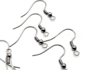 May include: Close-up of several silver-colored earring hooks. The hooks have a curved design with a coiled spring and a small ball at the end. The hooks are on a white background.