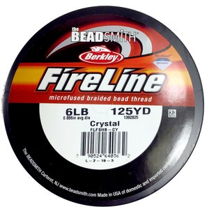 May include: A spool of black FireLine microfused braided bead thread fishing line. The spool is labeled with the brand name "Berkley", the product name "FireLine", the line size "6LB", the line length "125YD", and the line diameter "0.006in avg.dia". The spool also has a barcode and the text "Crystal FLFSH6-CY 1392825".