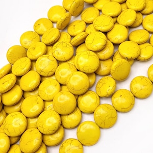 May include: A pile of bright yellow round beads with a crackled finish. The beads are made of natural stone and are perfect for jewelry making.