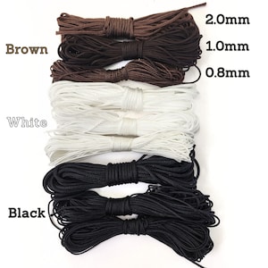 May include: Three spools of cord in brown, white, and black. The spools are labeled with the cord thickness in millimeters: 2.0mm, 1.0mm, and 0.8mm.