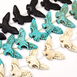 May include: A strand of turquoise and white bird-shaped beads. The beads are carved with intricate details and have a rustic, aged look.