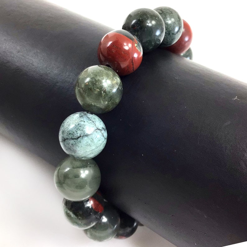 May include: A bracelet made of green and red gemstone beads. The beads are round and have a smooth, polished finish.